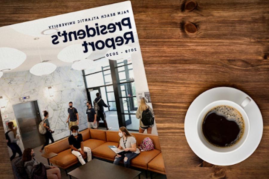 A copy of the Palm Beach Atlantic University's President's Report laying on a table next to a cup of coffee